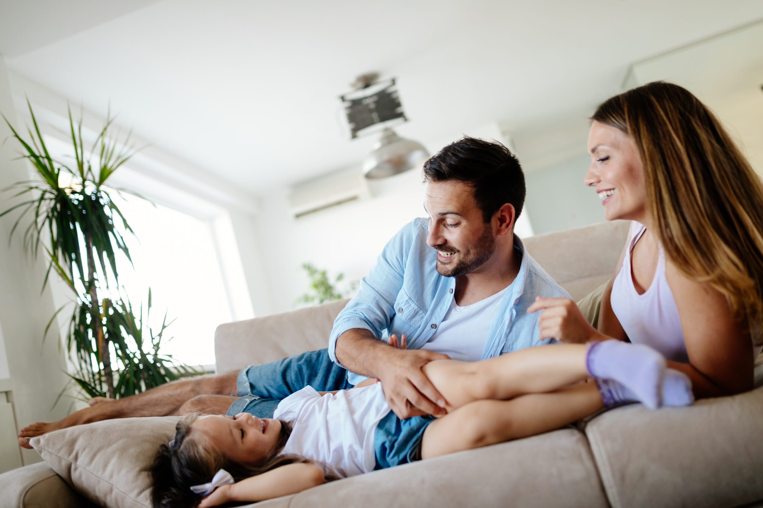 Happy family enjoying comfortable cooling from home air conditioning system in the UK